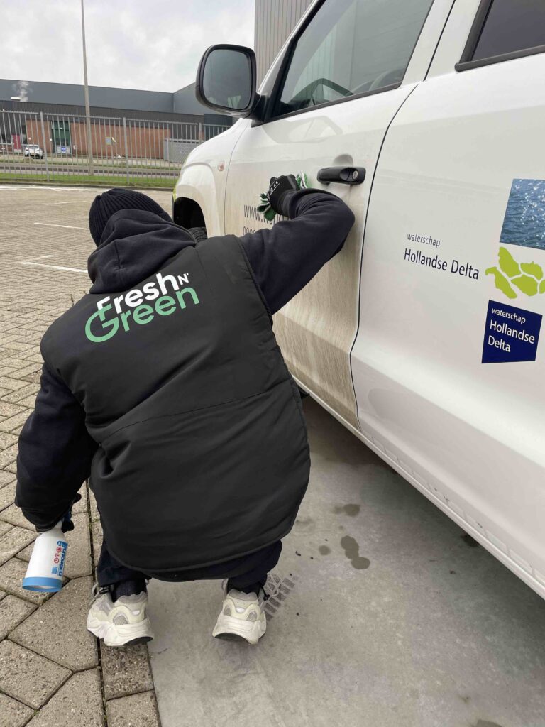 Fresh & Green medewerker reinigt een witte bedrijfs pick-up